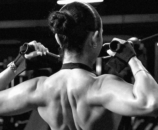Young woman fully contracting upper back and rear delt muscles while doing face pulls on a cable machine