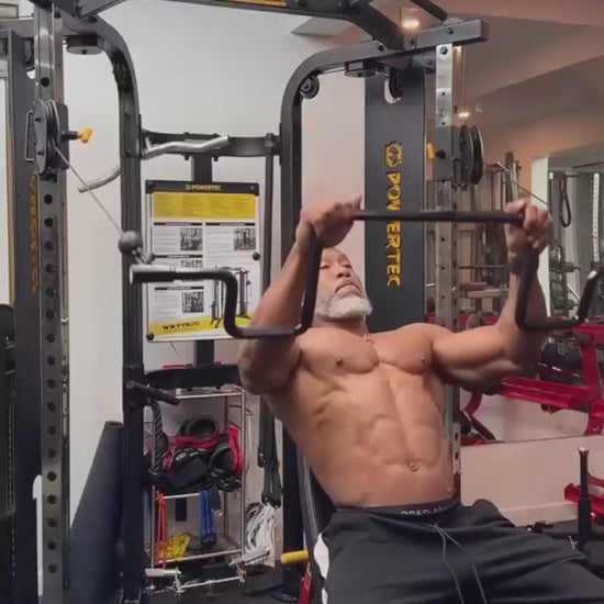 Muscular man performing cable lat pullovers with the Andreoni bar