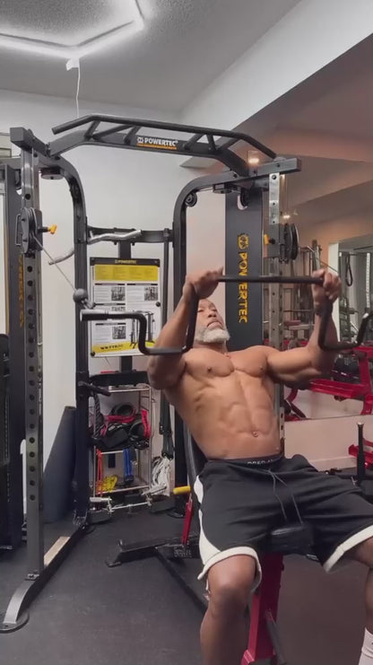 Muscular man performing cable lat pullovers with the Andreoni bar