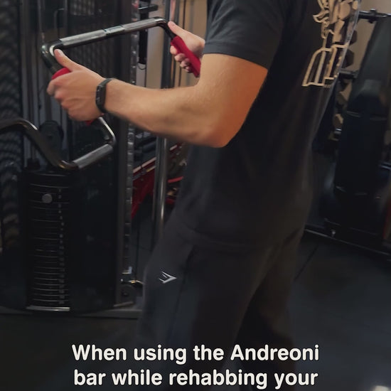 Young man in a home gym performing cable dips pushdowns or assisted dips with the Andreoni bar